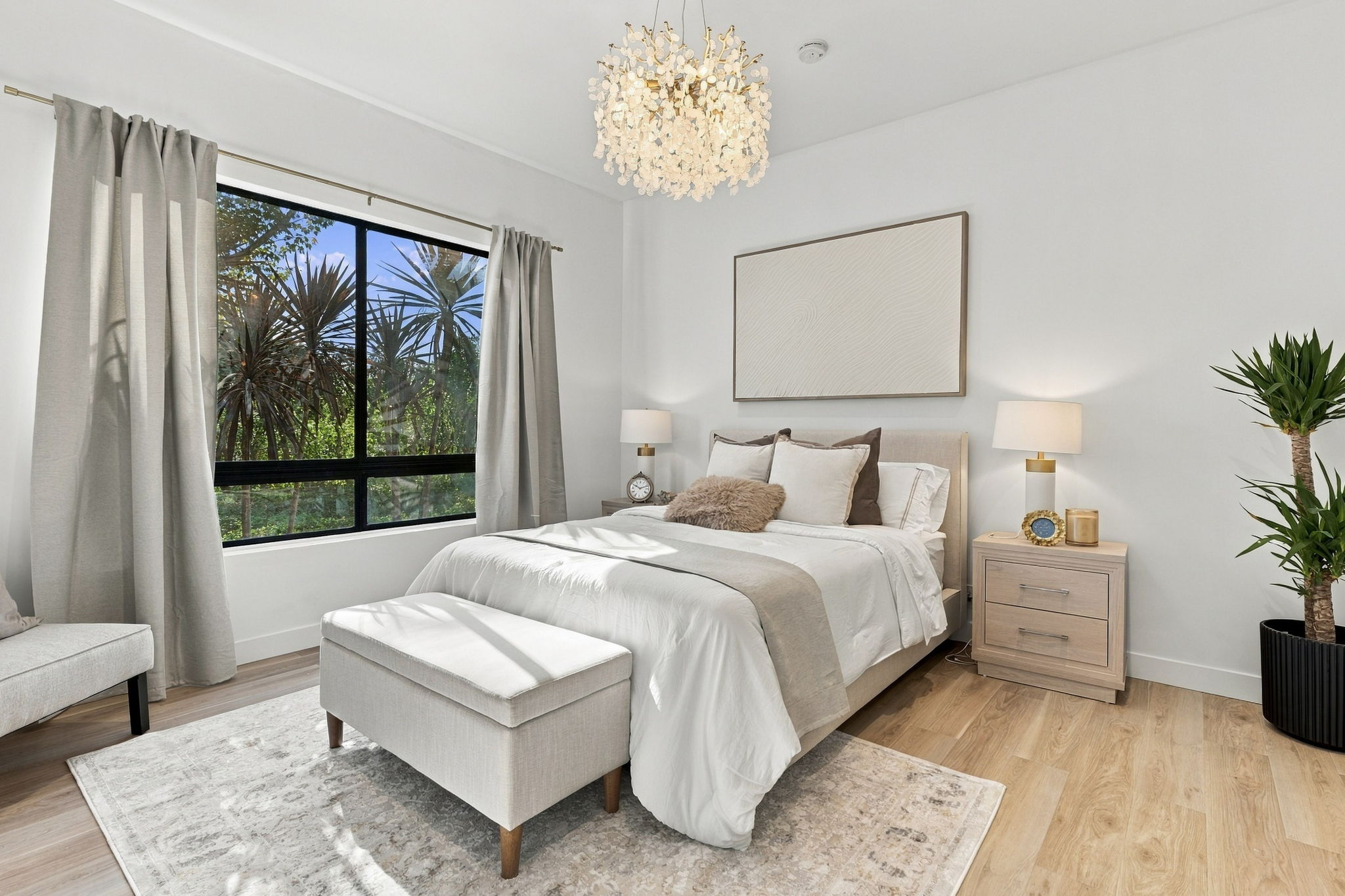 Primary bedroom with layered neutral textiles and an upholstered bench