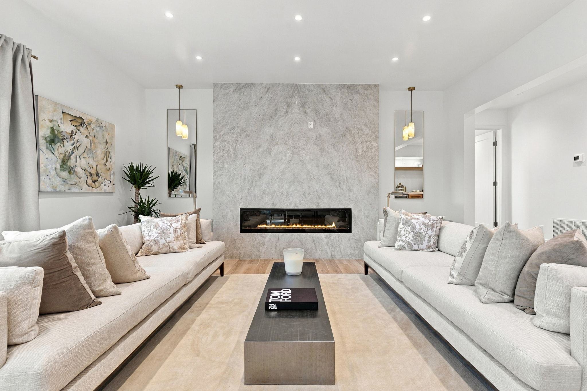 Symmetrical living room with cream sofas and a stone fireplace